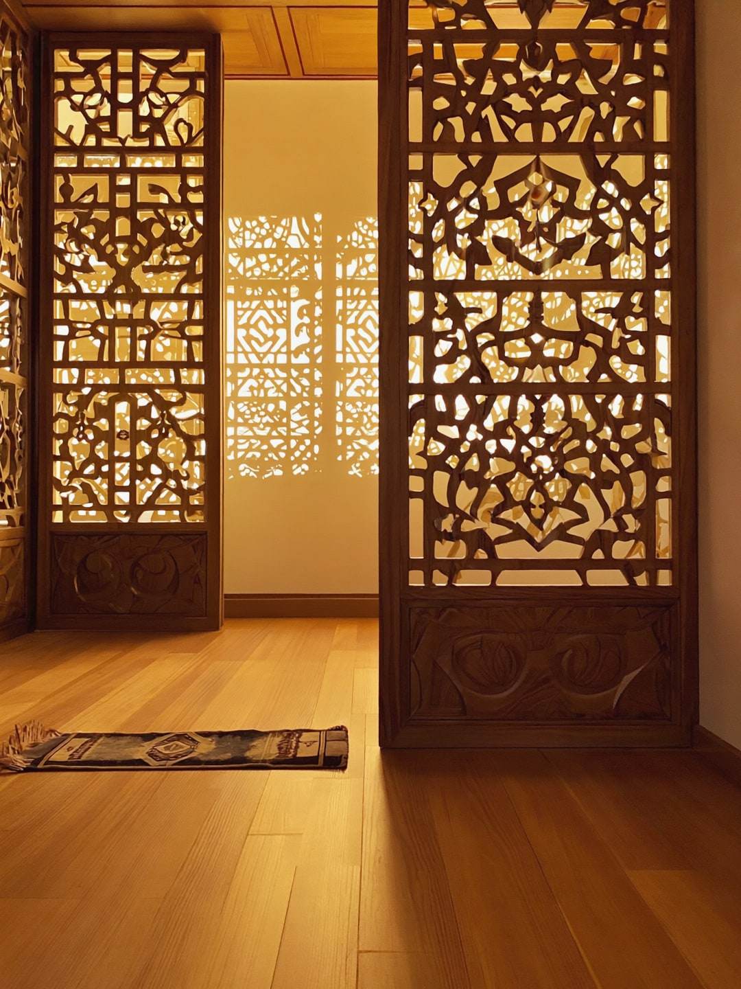 Surau yang tenang di sebalik skrin jati berukir tangan bermotif bunga Melayu.